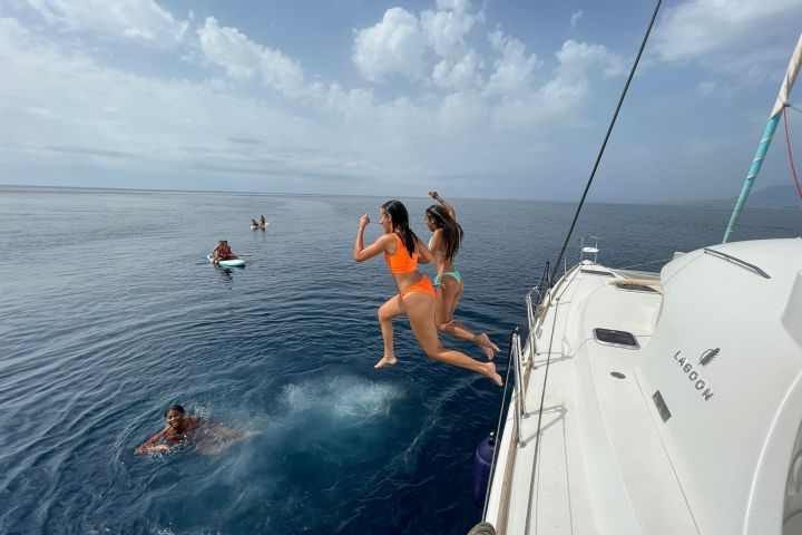a group of people riding on the back of a boat in the water