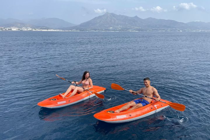 a group of people riding on the back of a boat in the water