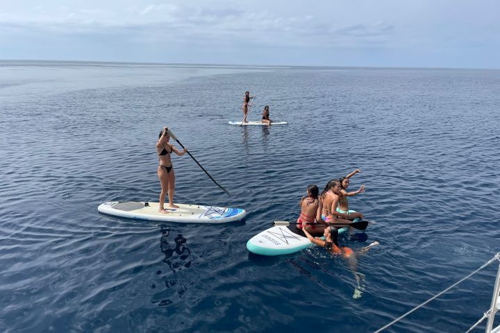 a group of people riding on the back of a boat in the water