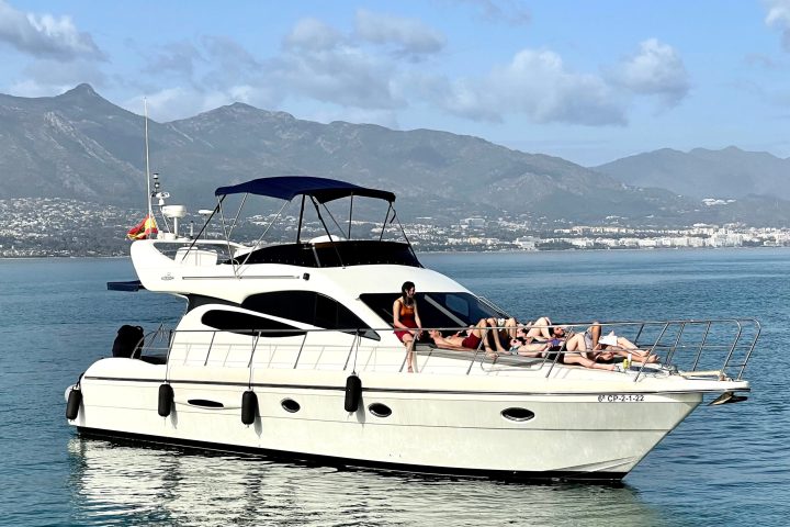 a large ship in a body of water with a mountain in the background