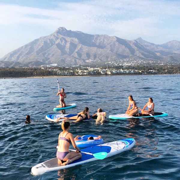 a group of people riding on the back of a boat in the water