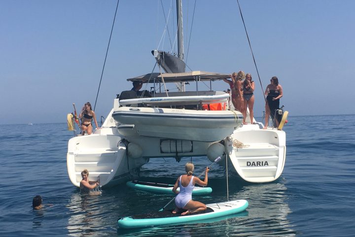 a group of people riding on the back of a boat in the water