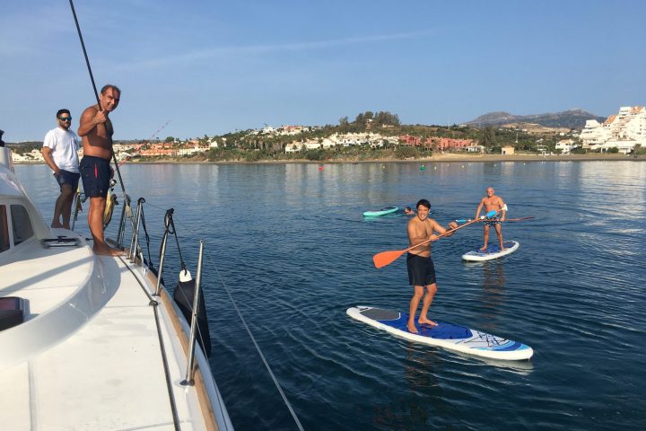 a group of people riding on the back of a boat in the water
