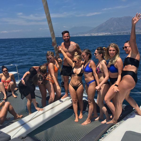 a group of people sitting next to a body of water