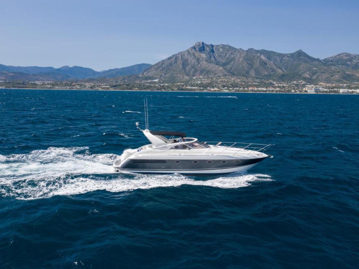 a small boat in a body of water with a mountain in the background