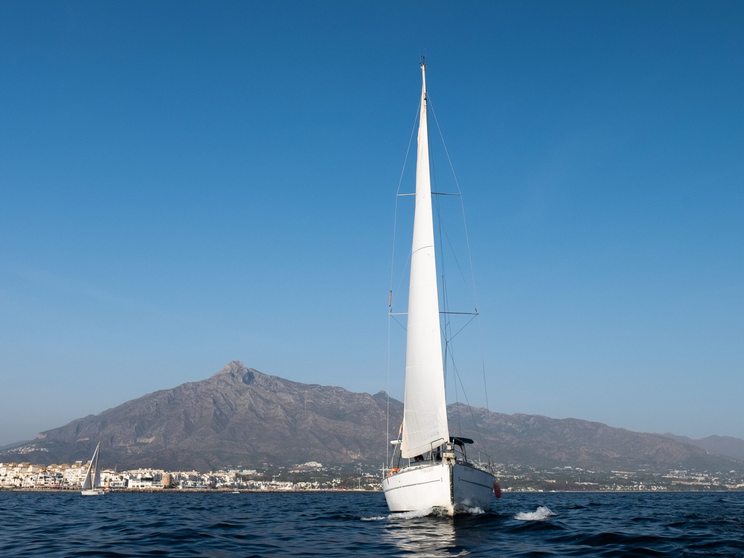 a boat on a body of water with a mountain in the background