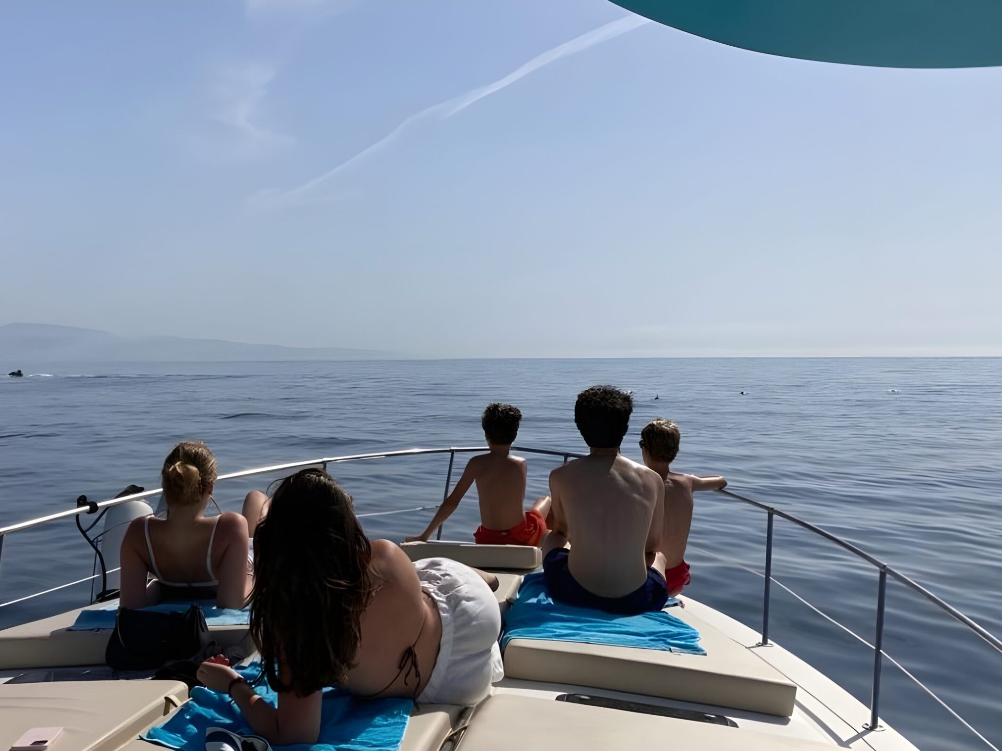 a group of people sitting in front of a body of water