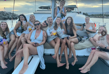 a group of people sitting on a boat posing for the camera