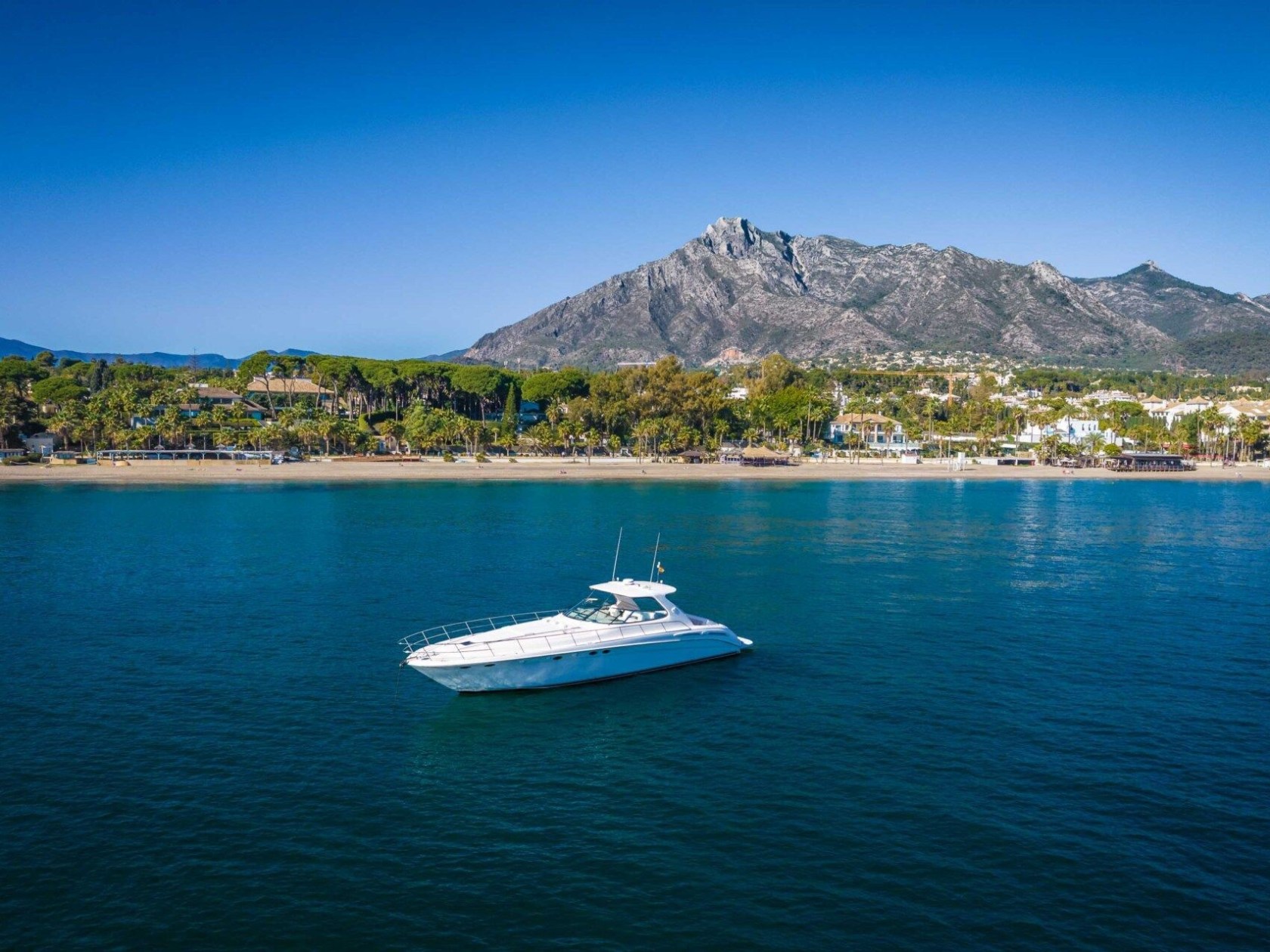 a small boat in a body of water with a mountain in the background