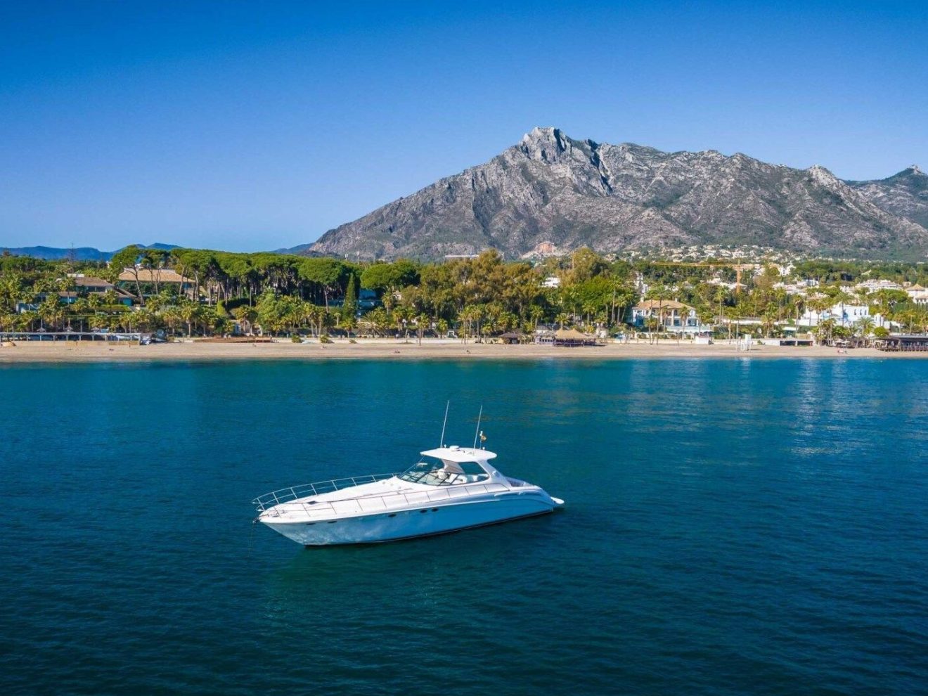 a small boat in a body of water with a mountain in the background