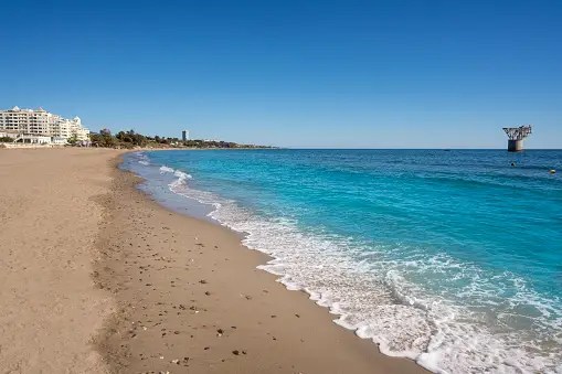 a sandy beach next to the ocean