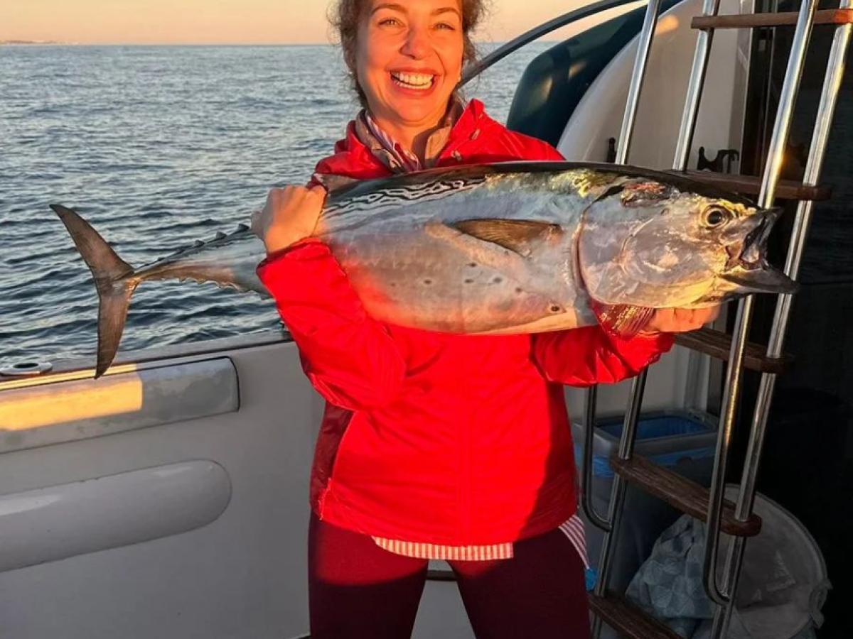a woman holding a fish in the water