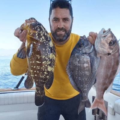 a man holding a fish posing for the camera