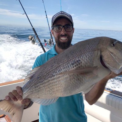 a man holding a fish in the water