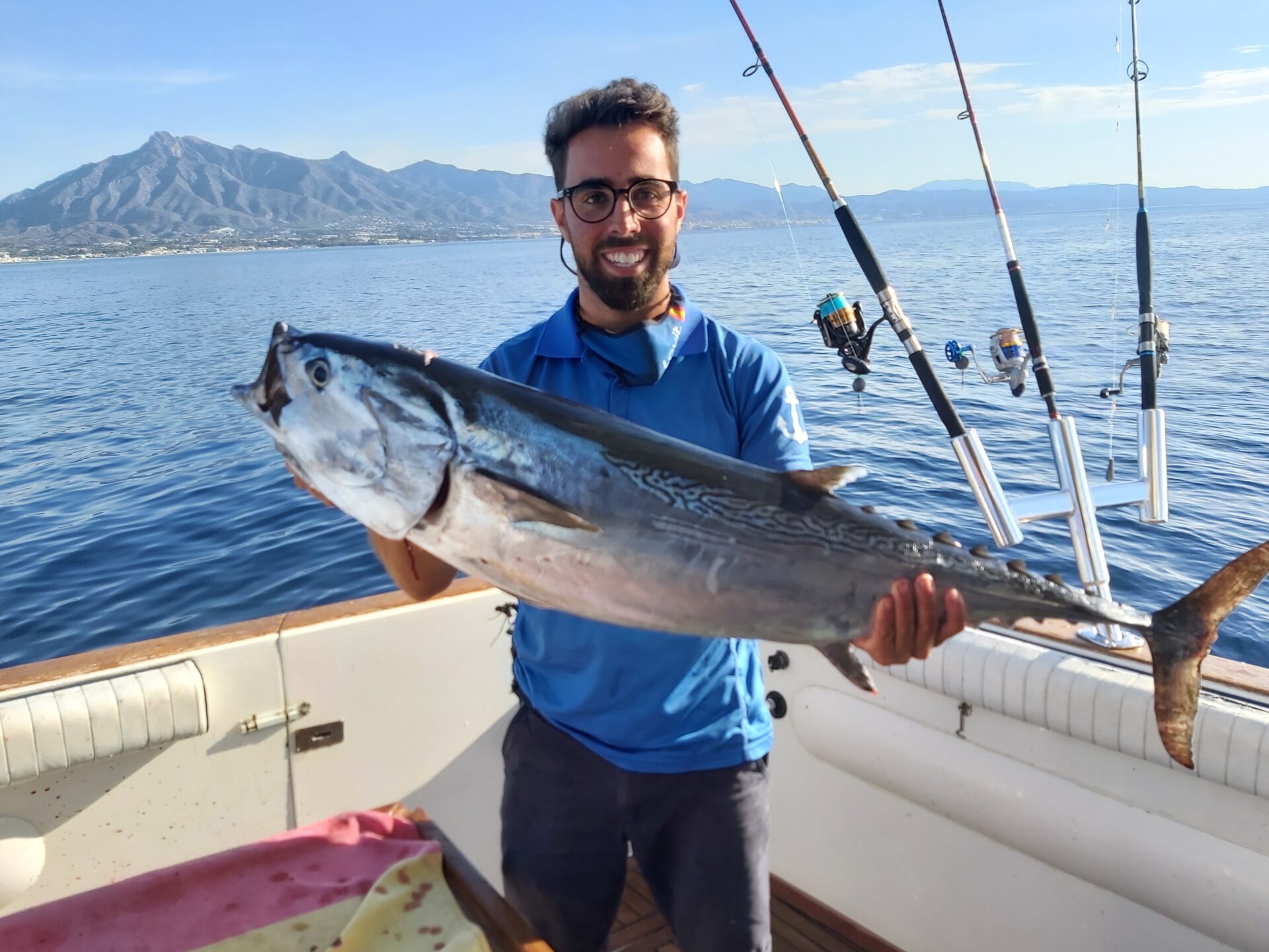 a man holding a fish on a boat in the water