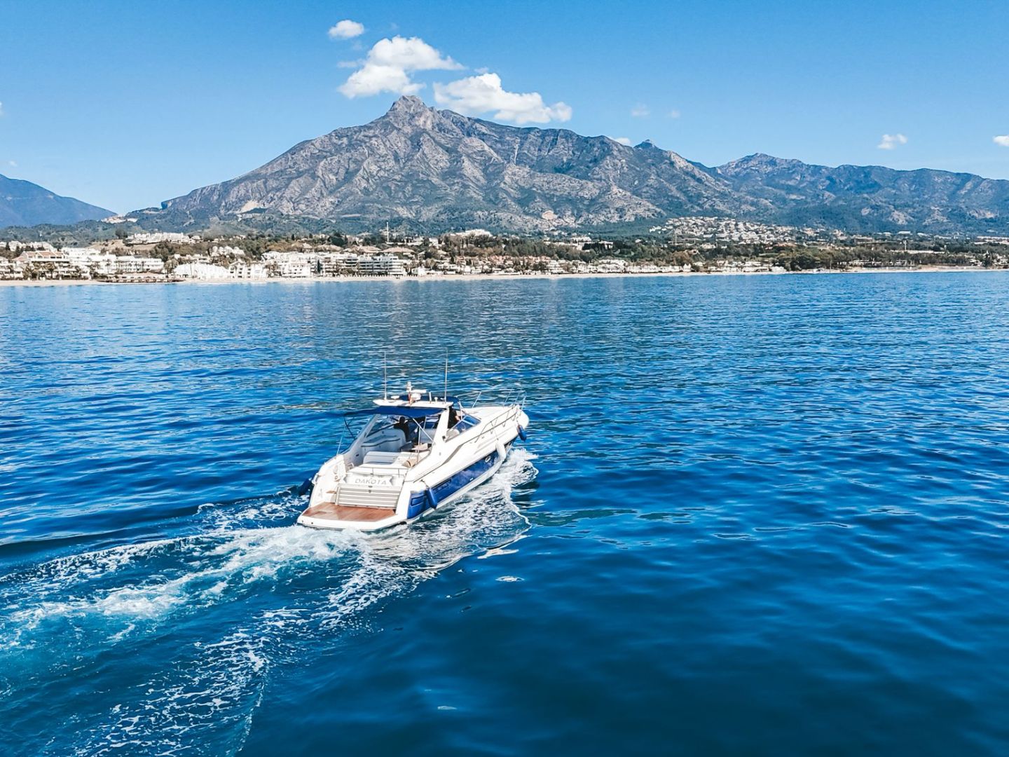 a small boat in a body of water with a mountain in the background
