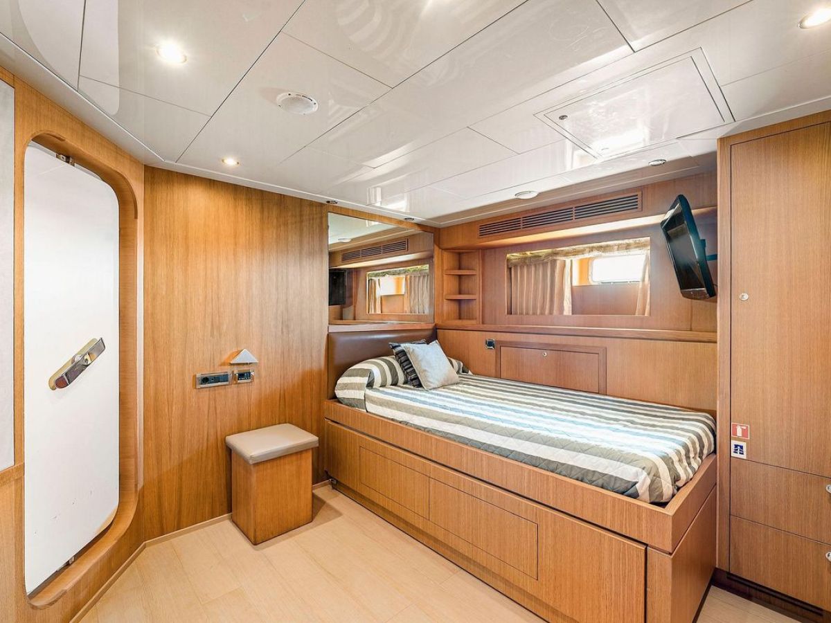 a kitchen with wooden cabinets and a bed