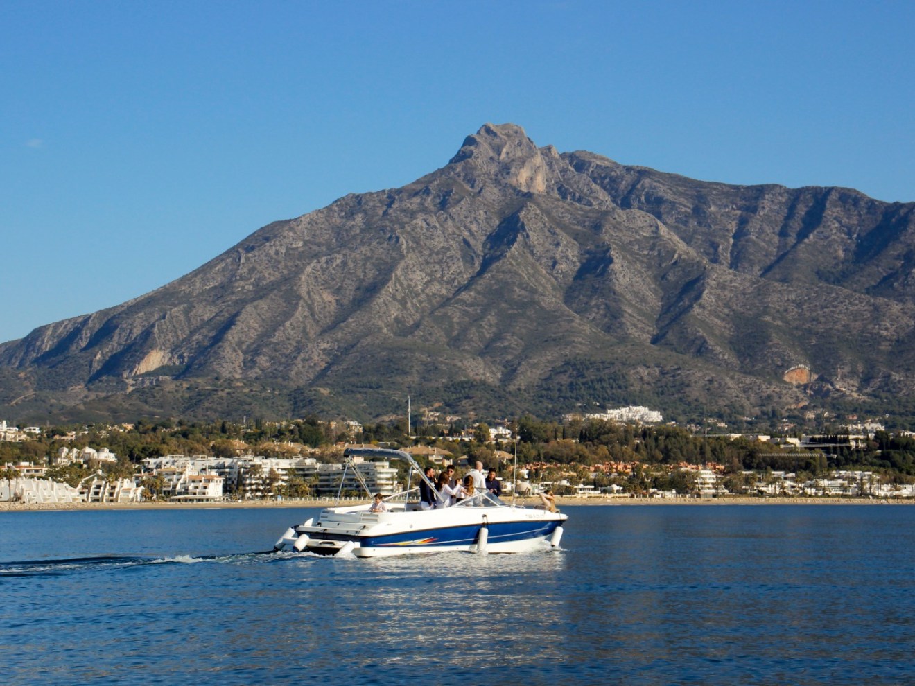 a small boat in a body of water with a mountain in the background