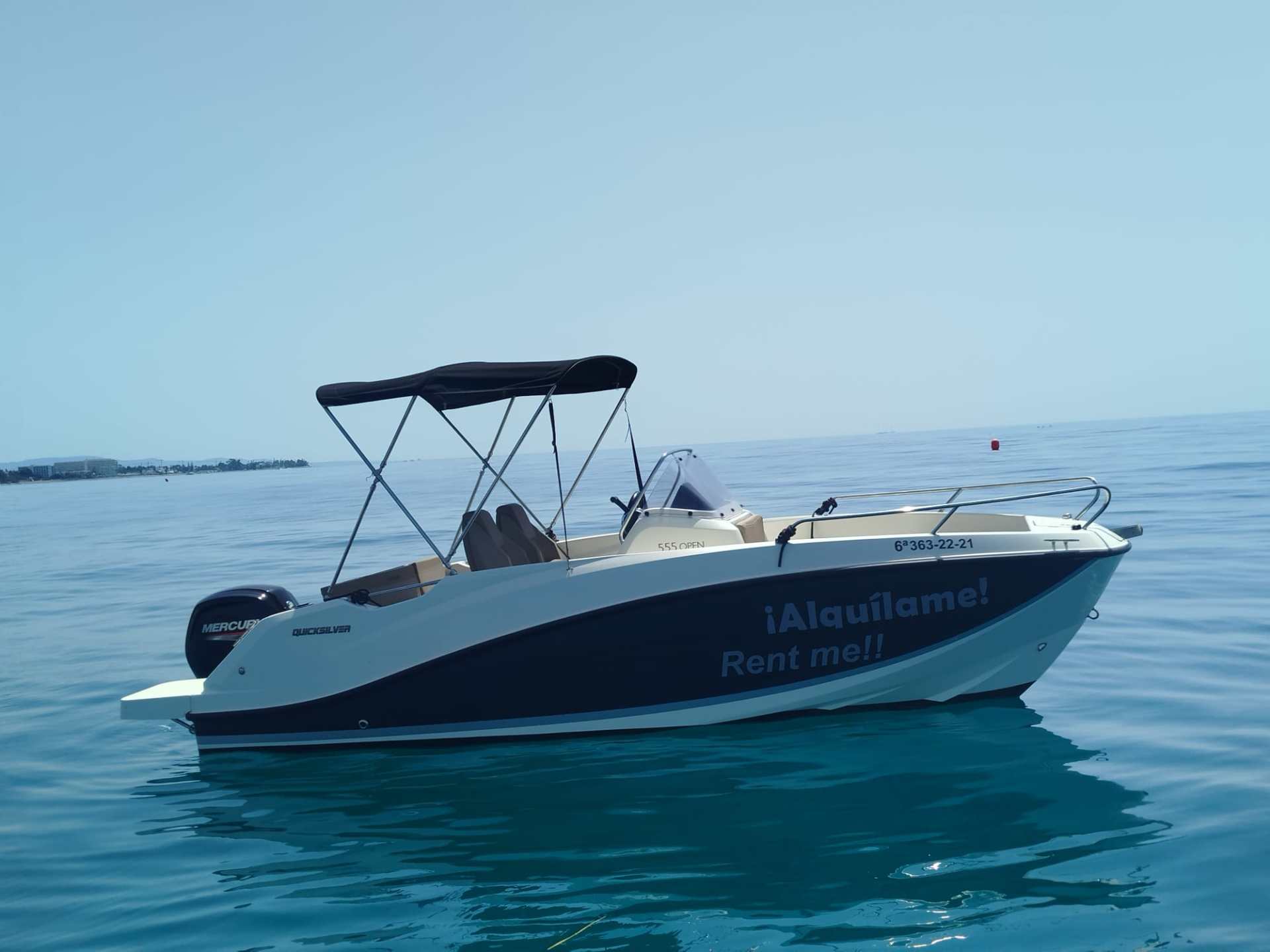 a blue and white boat sitting next to a body of water