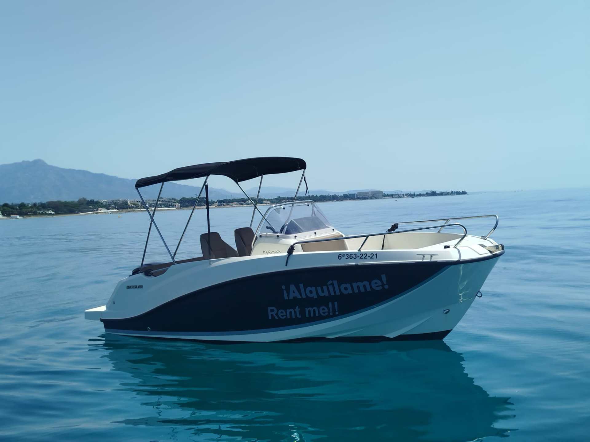 a blue and white boat sitting next to a body of water