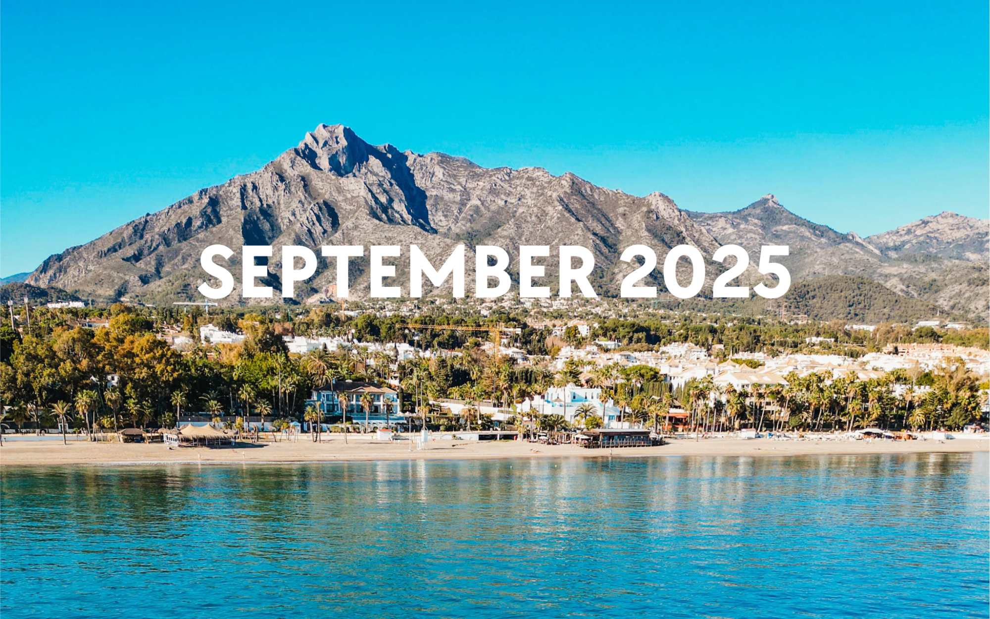 sept 2025 Beachfront town with mountains and 'September 2025' text overlay.