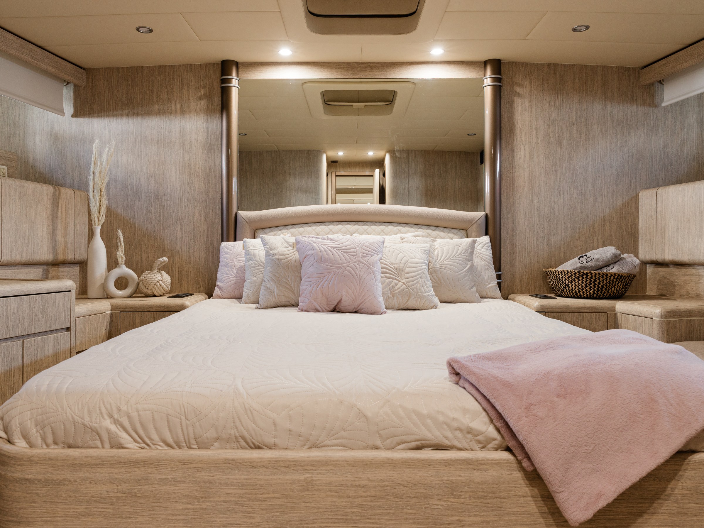 Modern bedroom with a large bed, soft pillows, decorative vases, and ambient lighting.