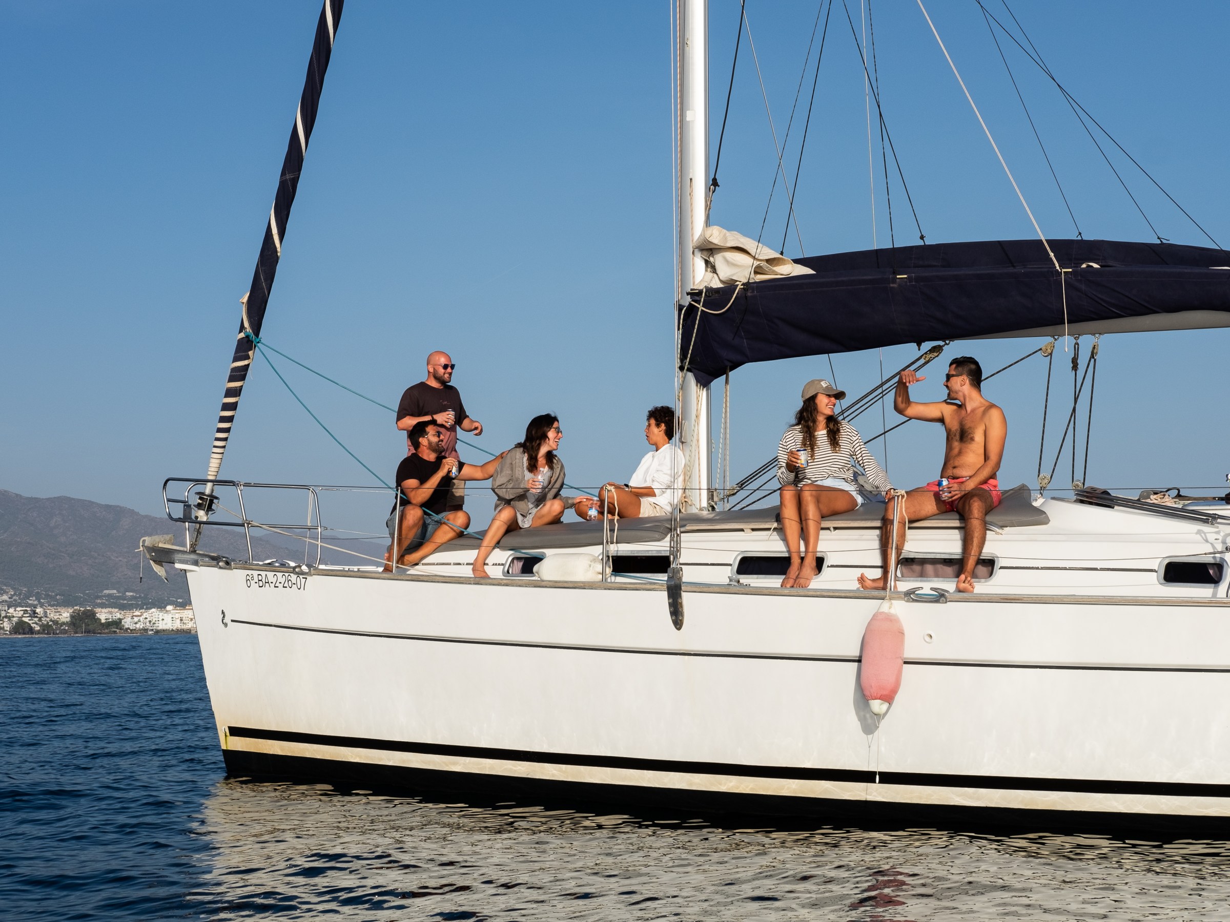 Group of people enjoying on a sailboat in sunny weather.