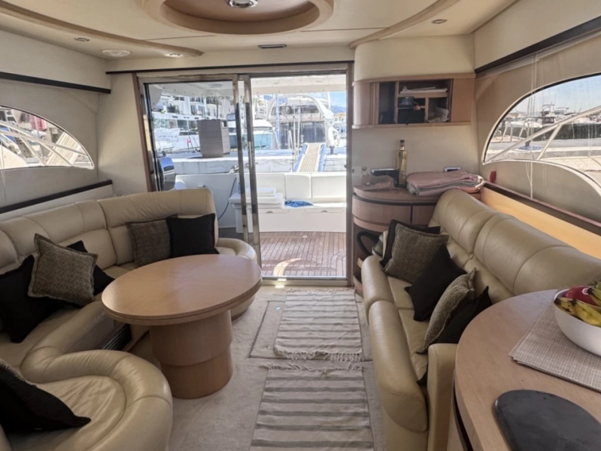 Luxurious yacht interior with seating, table, and fruit bowl.