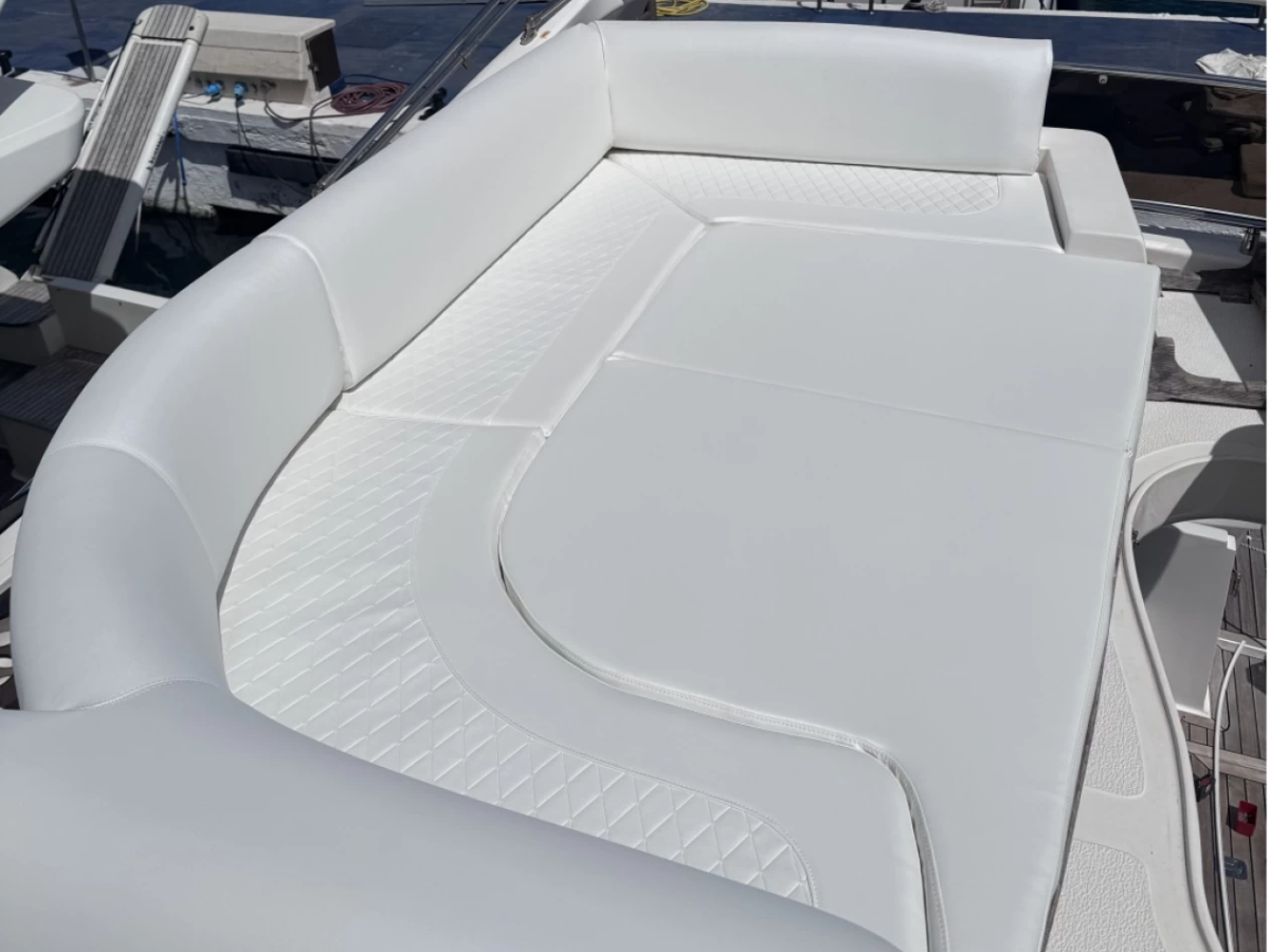 White cushioned seating on a boat deck under sunlight.