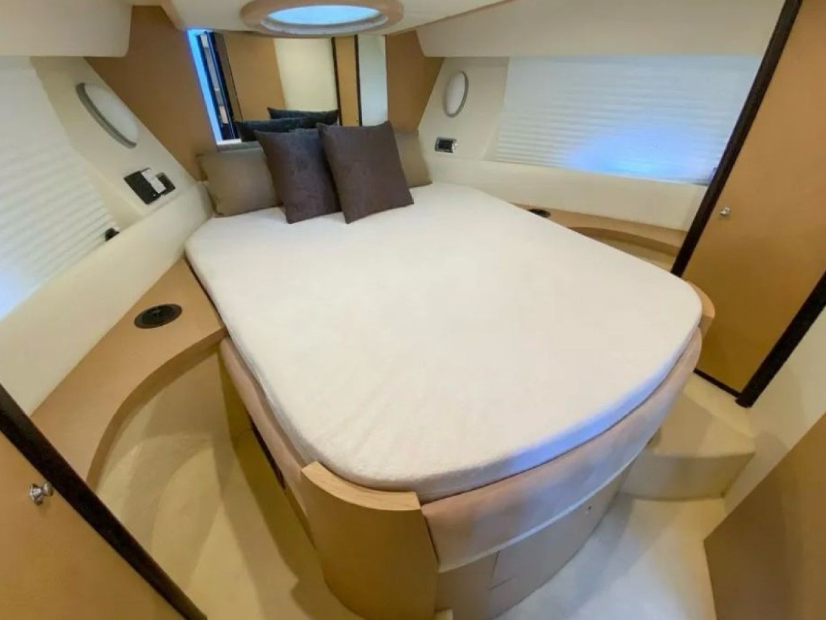 Elegant cabin bedroom with round bed, pillows, and modern decor.