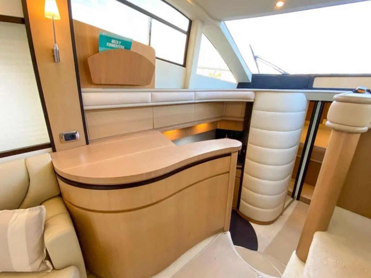 Interior of a modern boat with wooden paneling and cream seating.