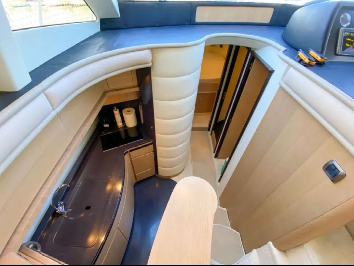 Spacious yacht interior with kitchenette and stairs to lower cabin.