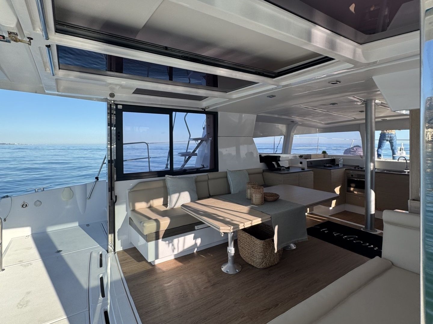 Luxurious yacht interior with seating, tables, and a view of the ocean.