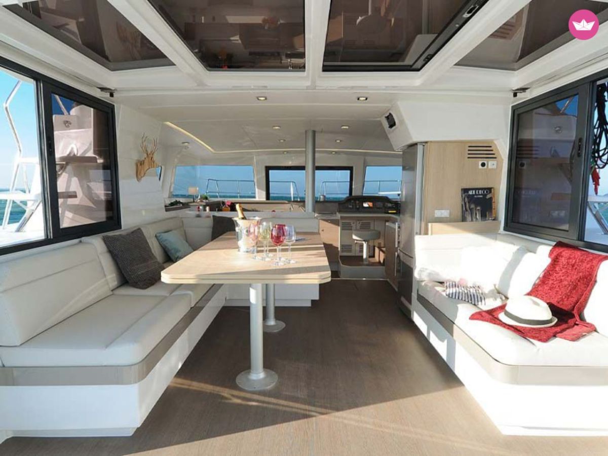 Modern yacht interior with seating, dining table, and nautical decor.